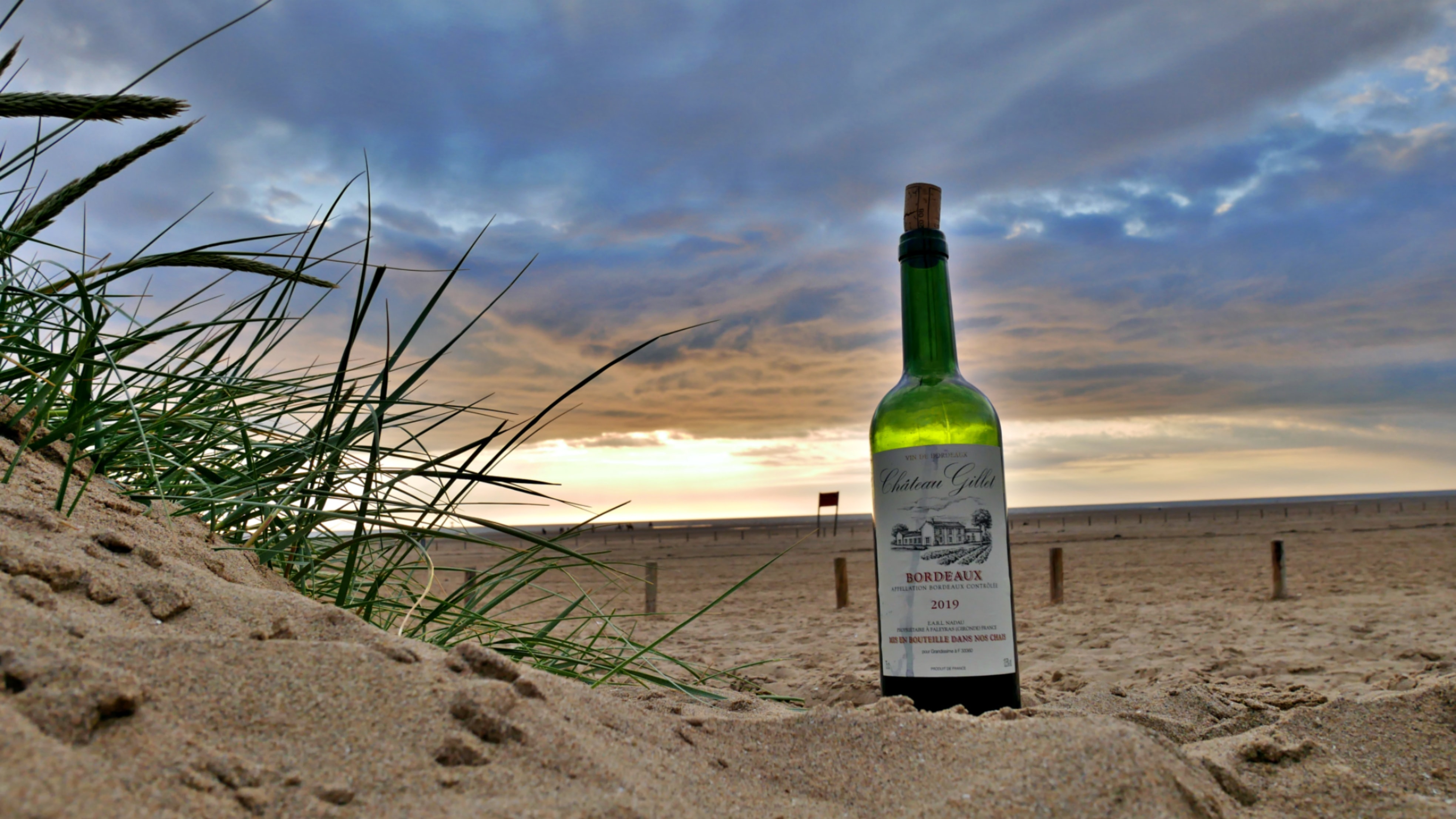 A bottle of bordeaux wine on the beach - self guided wine tour bordeaux