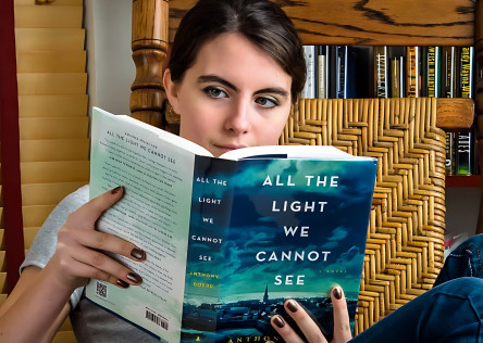 A woman reading the book All the Light We Cannot See