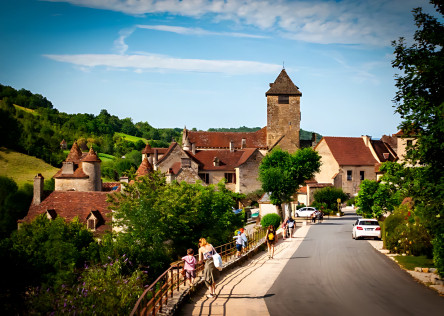 Stone houses surrounded by green countryside in a traditional French village