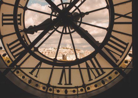 The clock at the Orsay Museum in Paris, with a view of the city through the glass