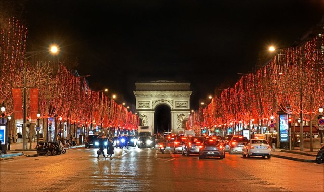 Champs Elysees Avenue in Paris, lined with trees with red Christmas lights