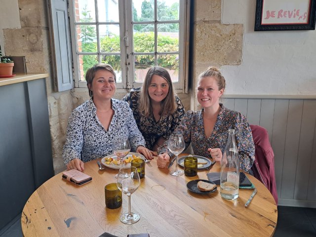 Emilie, Laura and Clelia, the trip planners at France Just For You, sitting at a table in a restaurant