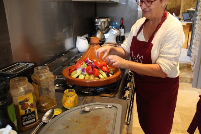 A B&B host in Dordogne preparing ingredients during a cooking class