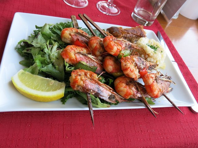 Grilled shrimps on skewers with lime and vegetables