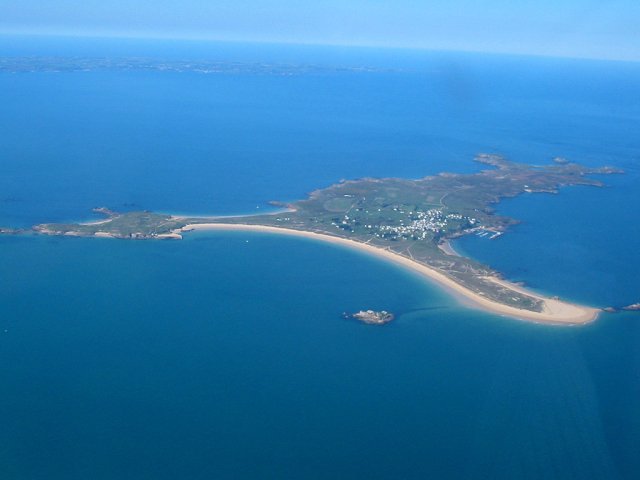 Birdseye view of Houat Island from the plane. It's shaped like a three armed boomerang, and you can see the beaches on the bottom and right side of the island