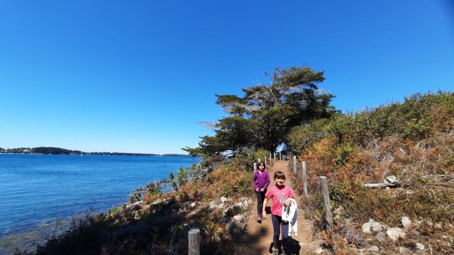 Two girls hiking on a coastal path on Ile aux Moines in Morbihan, Brittany