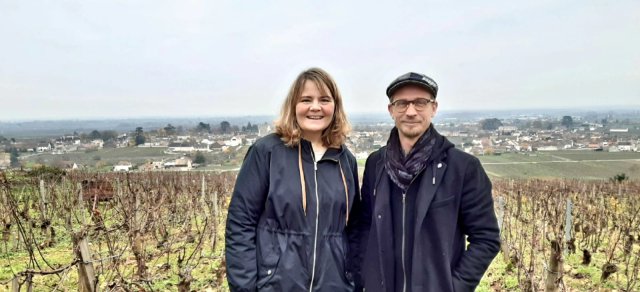 Senior Trip Planner Laura and wine tour guide Sebastien standing in front of a Burgundy vineyard