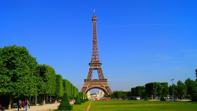 The Eiffel Tower in Paris in the summer against a blue sky