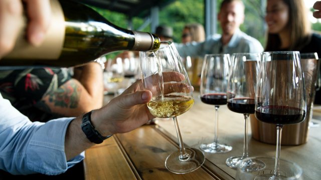 Ask your pourer questions about the wine White wine being poured into a glass at a wine-tasting
