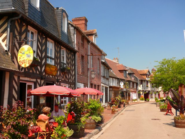 The half-timbered houses along a street in Beuvron-en-Auge on a sunny day in Normandy