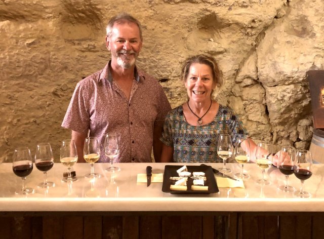 A couple at a wine tasting in a cave 