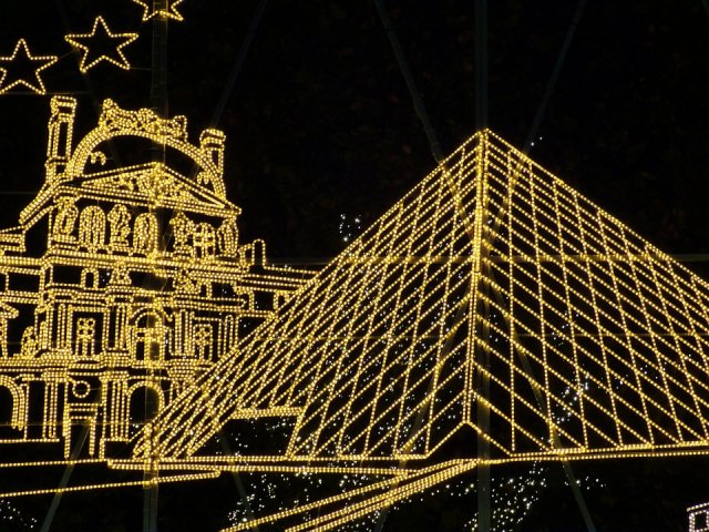 The Louvre museum and pyramid covered in Christmas lights