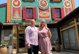 Travelers Julie & Mike celebrate their anniversary at Paul Bocuse Michelin-Star restaurant in Lyon Travelers Julie & Mike in front of Paul Bocuse Michelin-Star restaurant in Lyon