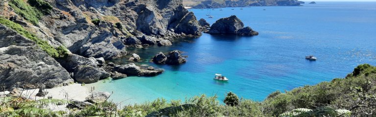 A beautiful beach in Brittany on Belle Ile island. The sea is turquoise and the sand is white. There are cliffs above the beach.