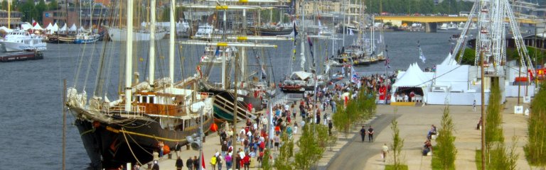 Tall ships along the Seine River in Normandy and people on the quays during the Rouen Armada