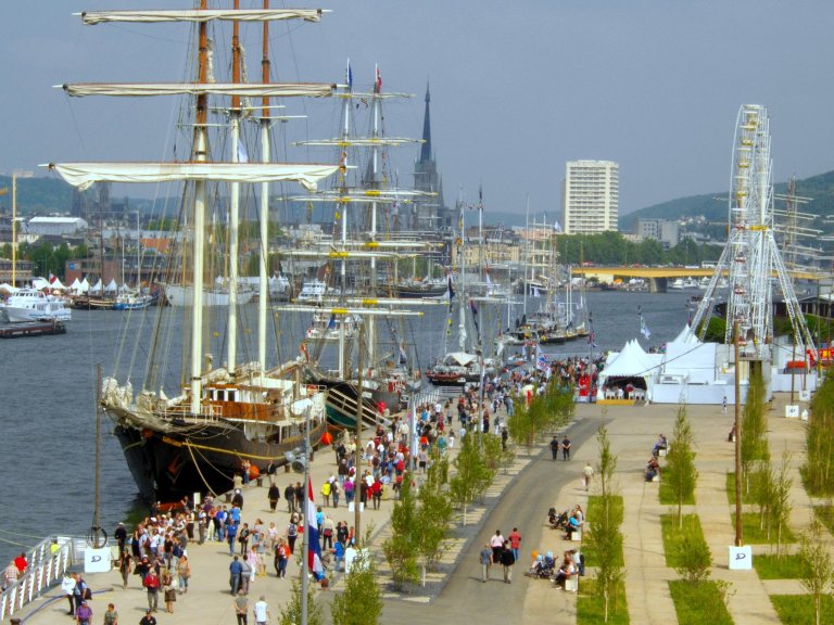 Tall ships along the Seine River in Normandy and people on the quays during the Rouen Armada
