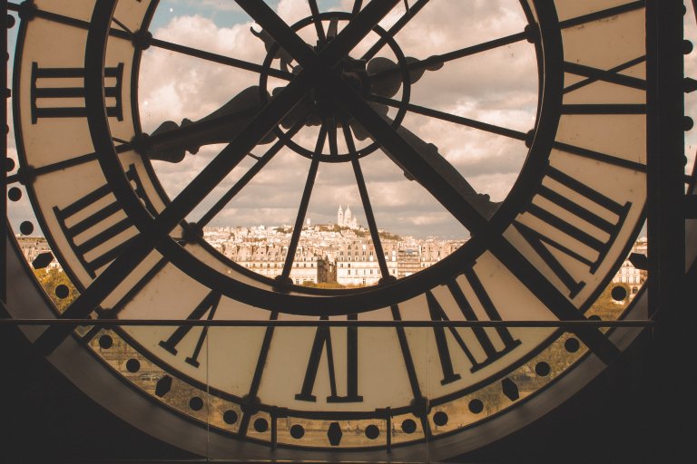 The clock at the Orsay Museum in Paris, with a view of the city through the glass