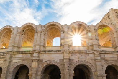 The arches of the Roman amphitheater with the sunlight shining through